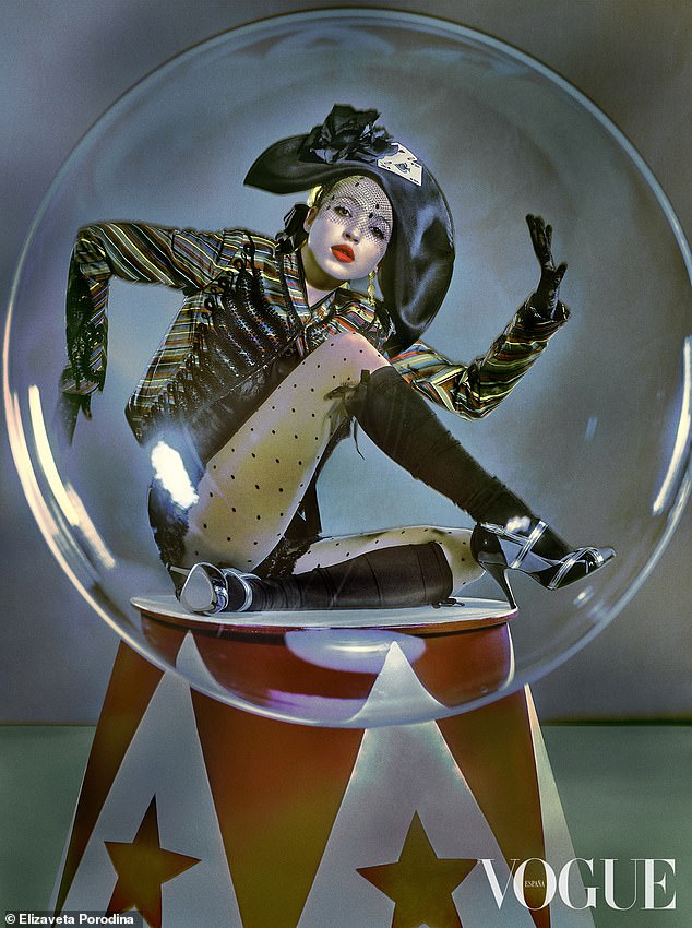 In another image, Lila wears a striped lace-up jacket and an oversized hat while making shapes while posing inside a snow globe.