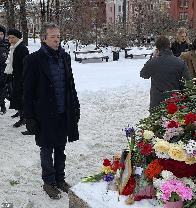 The British ambassador to the Russian Federation rises after laying flowers to pay his last respects to Alexei Navalny.