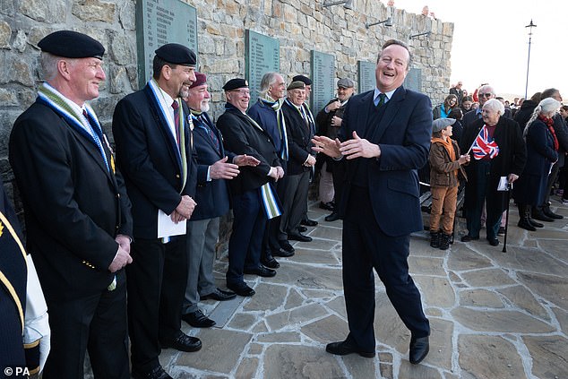 Lord David Cameron (right) attends a wreath-laying ceremony at the Falklands Conflict Memorial in Port Stanley, in the Falkland Islands, during his high-profile visit to show they are a "valuable part of the British family" amid renewed Argentine calls for talks about its future