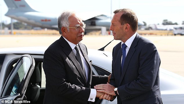 Then-Australian Prime Minister Tony Abbott (right) bids farewell to then-Malaysian Prime Minister Najib Razak after his visit to Perth during the search for missing Malaysia Airlines flight MH370 at Perth International Airport on April 3, 2014. .