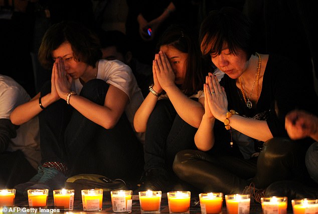 Chinese relatives of passengers from the missing Malaysia Airlines Flight MH370 participate in a prayer service at the Metro Park Hotel in Beijing, China, on 20