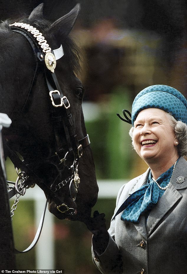 The late Queen Elizabeth smiling as she reviews mounted troops at the Royal Windsor Horse Show
