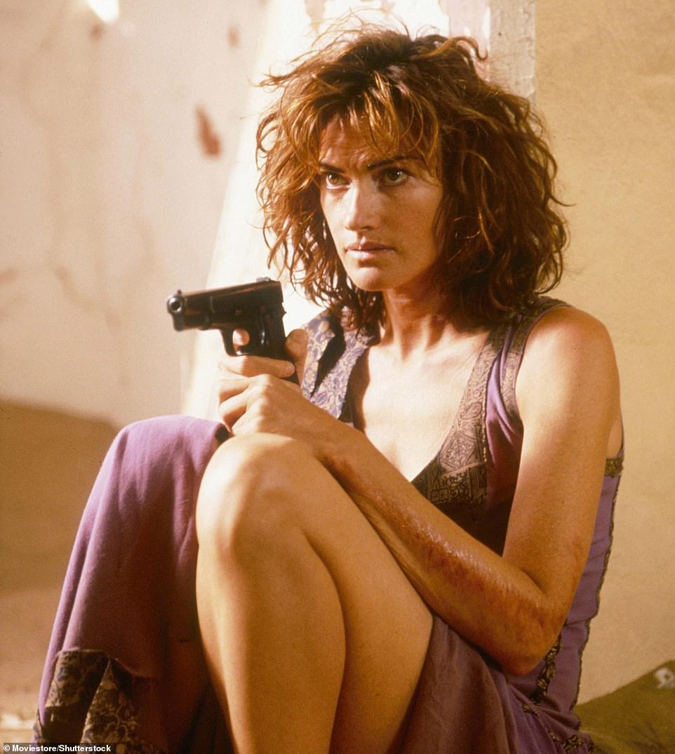The brunette seen in Dust Devil in 1992 while holding a gun and wearing a purple dress.