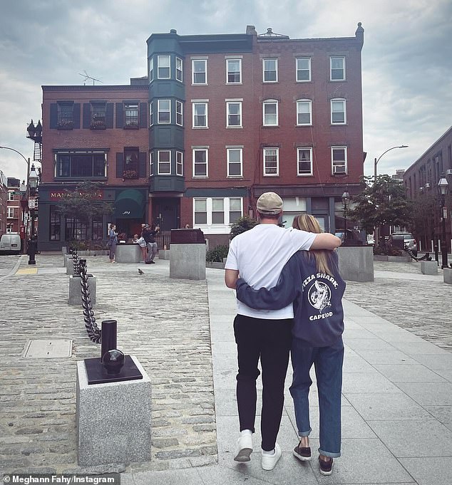Meghann posted a photo on social media of the couple with their backs to the camera as they walked with their arms around each other towards a large red building.