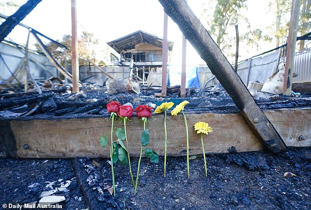 Roses and gerberas were left leaning on a piece of charred masonry at the site of the tragedy.