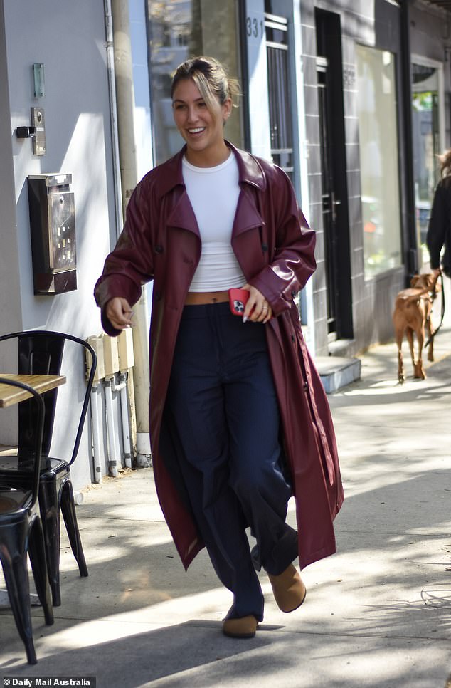 Sara looked chic in a maroon trench coat over a white top tucked into high-waisted navy blue pants.