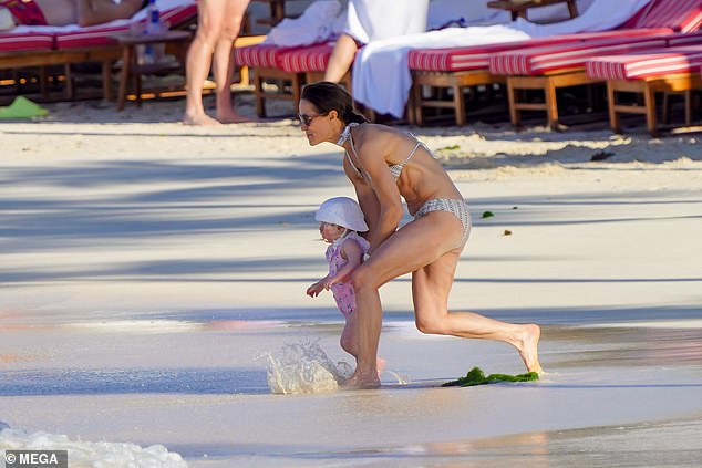 Pippa Middleton is seen holding her daughter in her arms as they enjoyed a day at the beach in St Barts earlier this month.