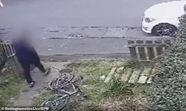 The thief looks at the bicycle after leaving the package