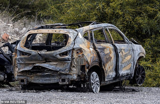 A burned car allegedly used by the perpetrators of the murder of Russian pilot Maksim Kuzminov to escape the scene of the incident is parked in front of the Spanish Civil Guard barracks, in El Campello, Spain.