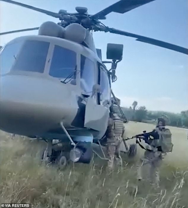 Pictured: Ukrainian intelligence officers inspect a Russian helicopter they say was delivered to Ukraine by Russian pilot Maksim Kuzminov.