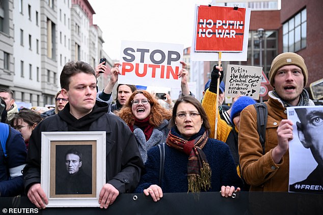 People hold banners as they attend a protest following the death of Russian opposition leader Alexei Navalny, in Berlin, Germany, February 18, 2024.