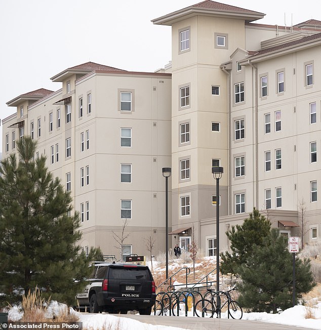 A police officer stands outside a dormitory at the Village at Alpine Valley housing Friday as police investigate a shooting on the University of Colorado-Colorado Springs campus.