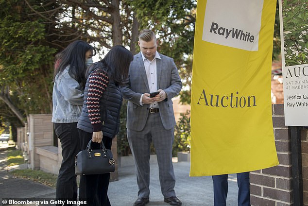 Someone earning an average full-time salary of $98,218 can now borrow $511,500, and RateCity reveals that banks can lend a borrower who has a 20 per cent deposit 5.2 times their salary (pictured, an auction of Sydney).