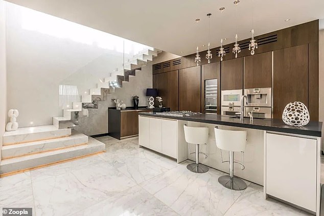 The contemporary kitchen includes a center island and large marble floor slabs.