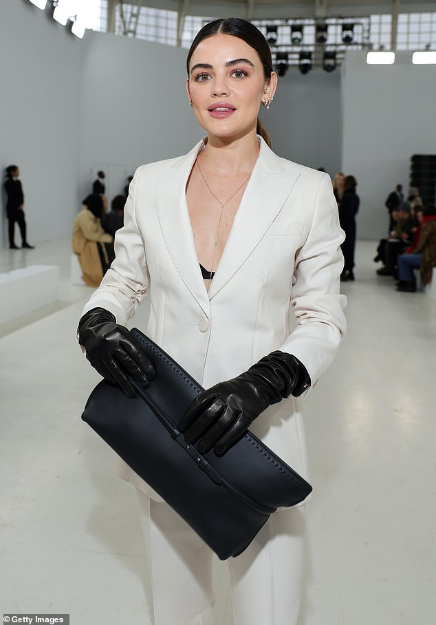 Lucy wore just a bra under her white jacket and completed the ensemble with black leather gloves, a large clutch and patent leather stilettos.