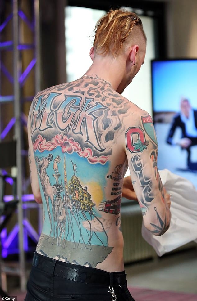 Perhaps the most distinguished of Kelly's tattoos is the large "MGK" extended piece over your upper back in a pink and blue gradient color