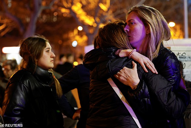 Devastated neighbors console themselves at the site of the large fire in the Campanar area