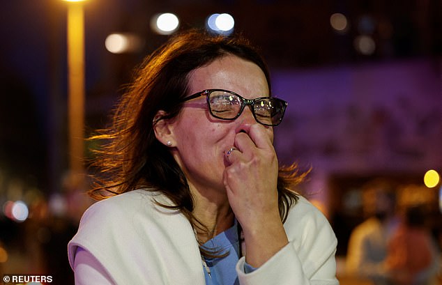 Building manager and resident Adriana fights back tears as she watches the block go up in flames.