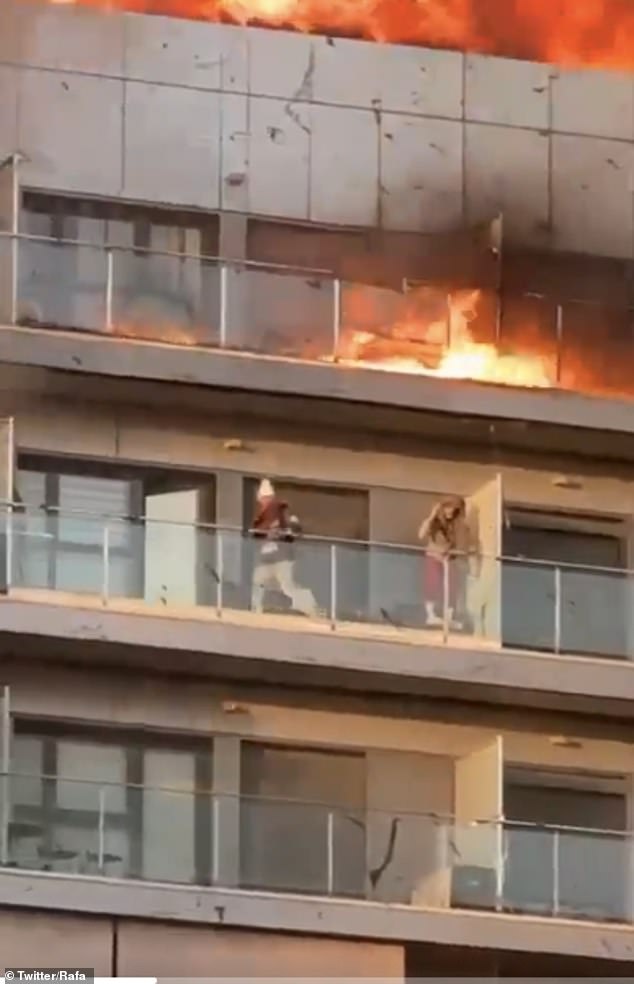 Dramatic footage shows two residents desperately trying to protect themselves from the fire. Firefighters rescued several people from their balconies.