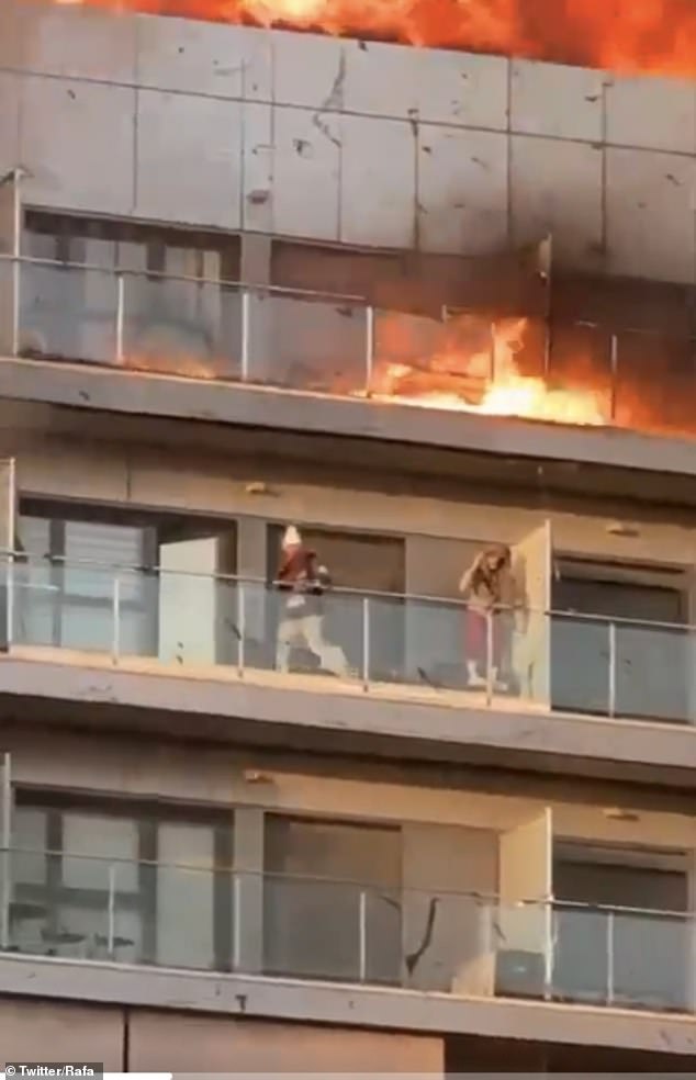 Dramatic footage shows two residents desperately trying to protect themselves from the fire.  Firefighters rescued several people from their balconies.