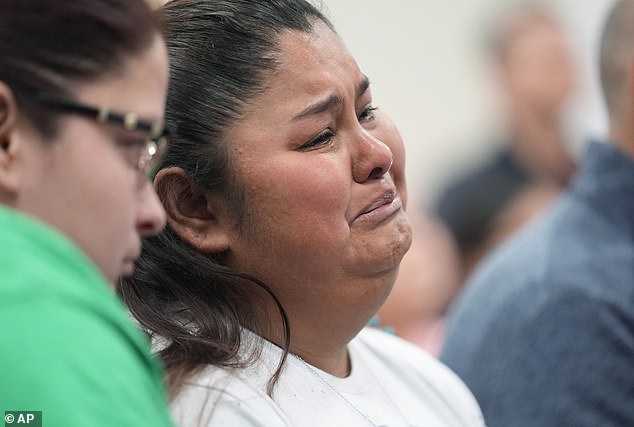 Evadulia Orta, left, Felicia Martínez, right, and other relatives of the shooting victims hold back tears as they listen to the scathing report.