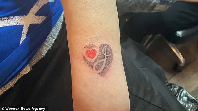 The tattoo features a black heart with Jamie's initial inside along with a smaller red love heart.