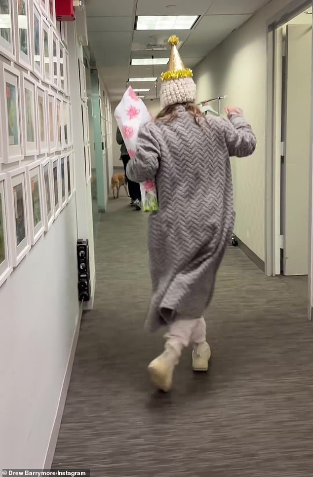 As the ET star danced down the hallway in a pink cable-knit sweater and pajama pants with a robe cardigan and a white knit hat, her staff came out of her office doors to wish her a happy birthday, and she stopped to hug each one