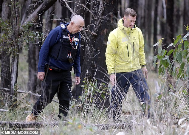 Coroners are seen scouring the Mt Clear bushland in search of Ms Murphy on Friday.