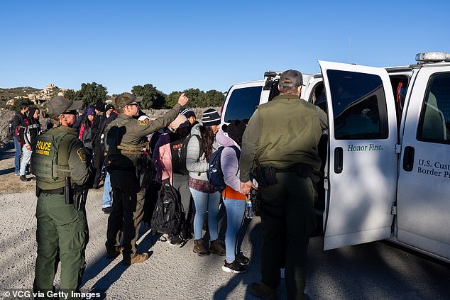 Migrants board a US Border Patrol vehicle on February 13, 2024 in San Diego, California