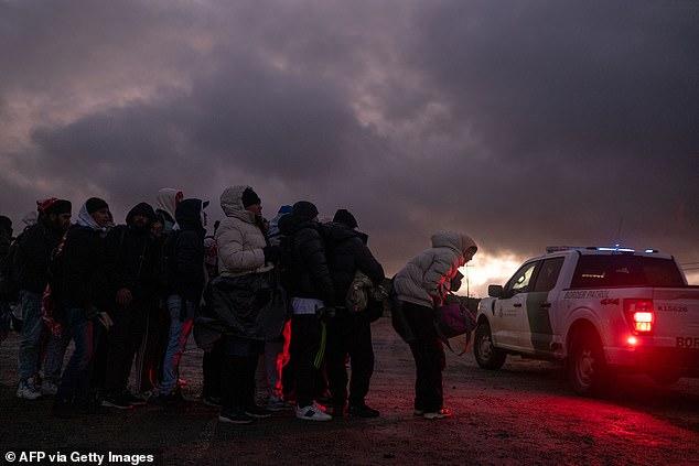 Asylum seekers wait in line to be processed by Border Patrol at a makeshift camp near the US-Mexico border east of Jacumba, San Diego County, California, January 2, 2024.