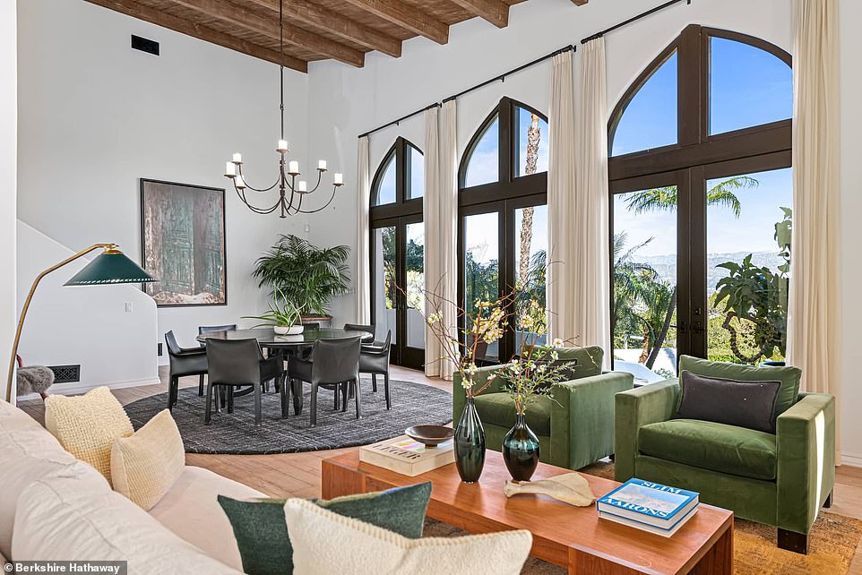 Inside the split-level living room, hardwood floors and high wood-beamed ceilings create an intimate atmosphere.