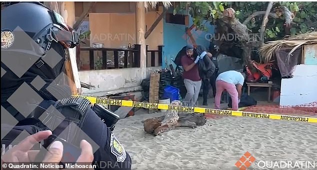 Mexican law enforcement officers remove body bags containing the bodies of two men who were found tortured to death inside a cabin on an Acapulco beach on Thursday.