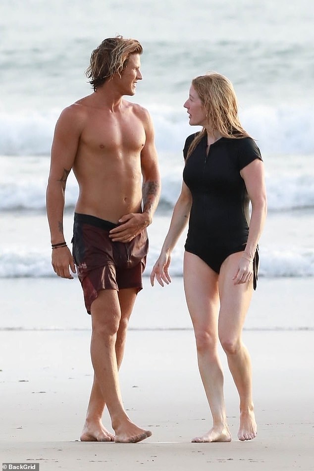 The pop star and the handsome surf instructor enjoy each other's company in the sand