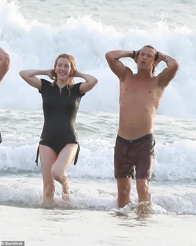 The couple emerges from the ocean after swimming.