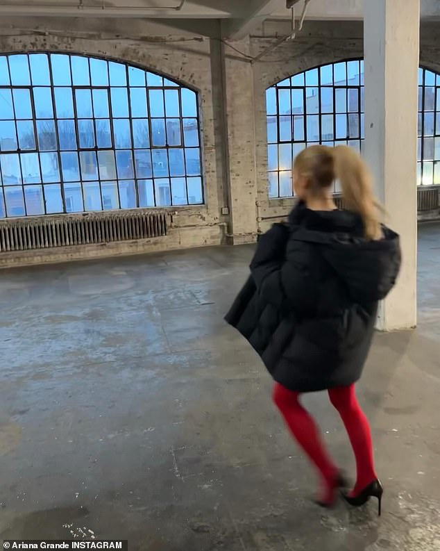 The Thank U, Next star could also be seen running in an empty room wearing red tights and a black puffer coat.