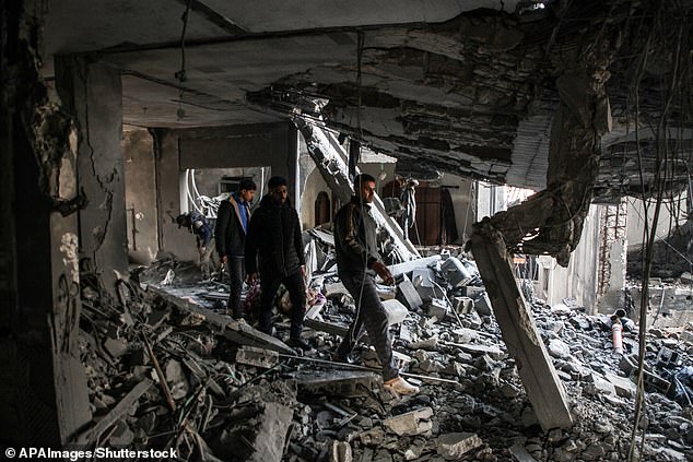 Palestinian artist Mahmoud Zuaiter inspects the ruins of his house after an airstrike on the house in Deir al-Balah, central Gaza Strip, on February 24.