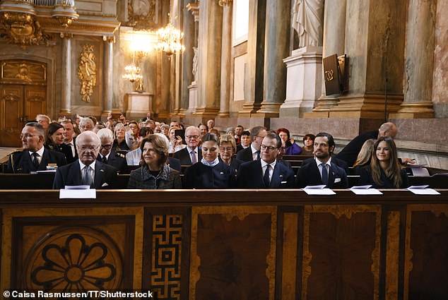 Members of the Swedish Royal Family sit on the benches to pray for peace in the Royal Chapel
