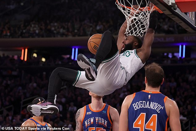 Jaylen Brown hangs on the rim after a dunk against Knicks guard Josh Hart on Saturday