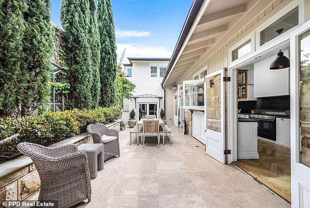 Situated on one of Paddington's most sought-after streets, this two-storey antique stone house is an elegant blend of Old World charm with modern luxury. Pictured: The travertine terrace built next to the kitchen is perfect for alfresco dining.