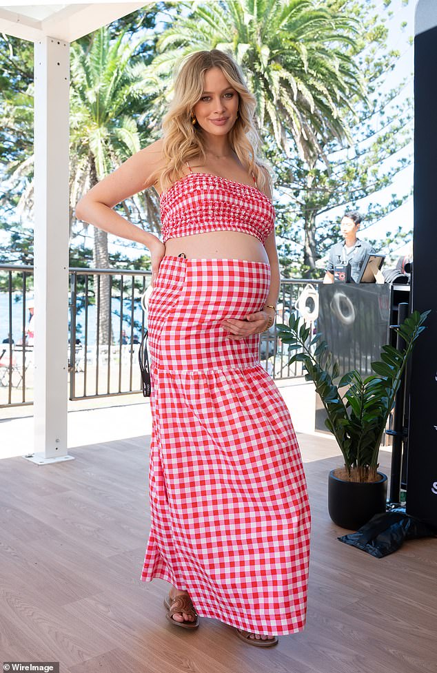 The model, who is expecting her first child with celebrity personal trainer Jono Castaño, cradled her baby bump as she posed in a flirty summer ensemble.