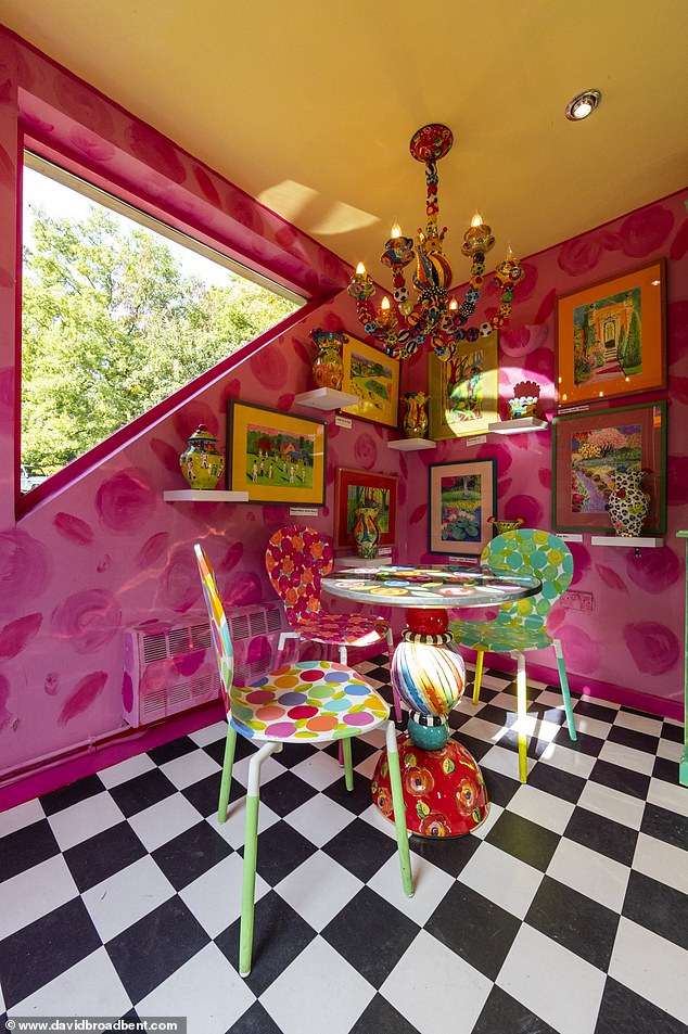 Her dining area has a magenta wallpaper with black and white scrolling flooring.  Mary also has a miniature version of the chandelier from her workshop here.
