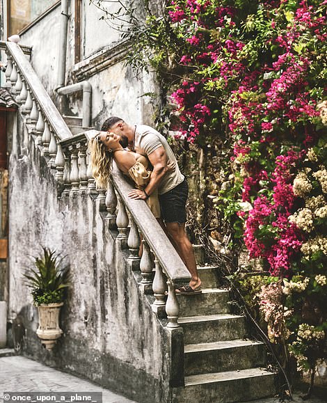 In Kuala Lumpur, Malaysia, the couple stopped to take a photo next to this eye-catching wall of flowers.