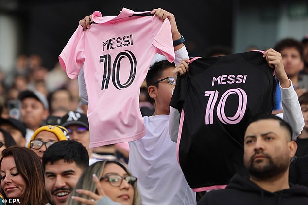 Fans hold Miami jerseys with Lionel Messi's name before Sunday night's game.