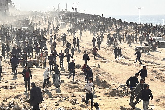 Palestinians wait for humanitarian aid on a beach in Gaza City, Gaza Strip, on Sunday.