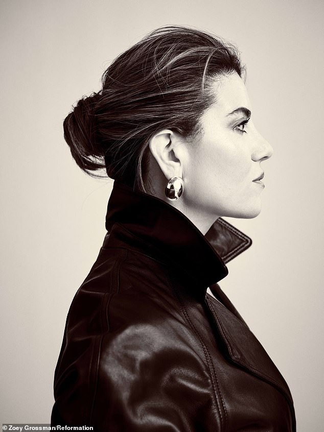 A profile view of Lewinsky wearing a sleek Veda Ashland black leather trench coat
