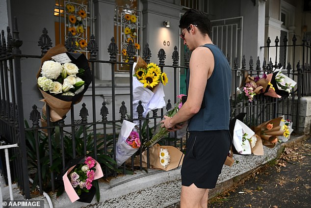 A man places flowers at Jesse Baird's Paddington residence in Sydney on Saturday.