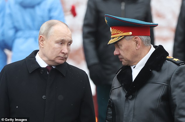 Russian President Vladimir Putin listens to Defense Minister Sergei Shoigu participate in the wreath-laying ceremony at the Tomb of the Unknown Soldier on the occasion of Defender of the Fatherland Day on Friday.