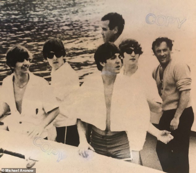 A group photo shows Paul McCartney (center), the band's bassist, with a towel wrapped around his shoulders, standing next to George Harrison.