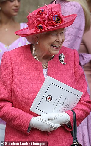The Queen looked delighted as she smiled outside St George's Chapel, carrying the order of the wedding service.