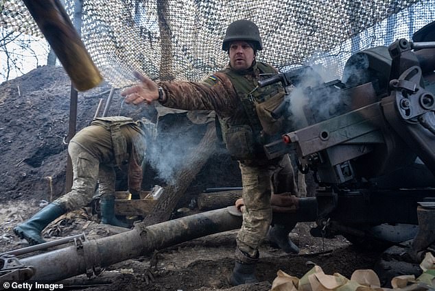 Ukrainian gunner Vasyl Zozulia removes a smoking casing after firing the weapon.